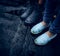 Feet on the pavement. two girls in bots and rubber boots standing the asphalt in the rain. close-up