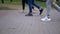 Feet of People, Passers-by Walk on Paving Slabs in Park. Slow motion