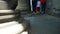 Feet of the people walking along colonnade of ancient temple