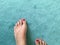 Feet with red nail polish on azure carpet