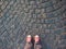 Feet in red sneakers on the pavement top view, informal style