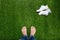 Feet resting on grass with lying sneakers