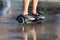 Feet ride of a man on a segway on the wet asphalt