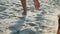 Feet running in the sand. Jogging man closeup barefoot runner legs and feet on the beach. Sporty legs exercising on a