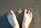 Feet in the sand with a starfish in the middle