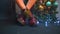 Feet of a seated girl, crossed near a New Year tree at a party.