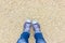 Feet selfie. Female feet in blue sneakers on a pebble beach