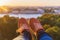 Feet selfie tourist on sunset from the height against the cityscape