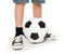 Feet shod in sneakers and soccer ball