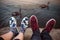 Feet with shoes of the couple on romantic date sitting on the rocks near lake