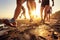 Feet in shoes, running athletes on the beach along the sea at sunset.