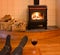 Feet of a single man relaxing by fire with wine