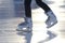 Feet on the skates of a person rolling on the ice rink