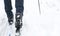 Feet of a skier in ski boots on cross-country skis. Walking in the snow, winter sports, healthy lifestyle. Close-up,