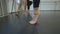 Feet of slim Caucasian young woman warming up rehearsing in dance studio with friends. Unrecognizable barefoot female