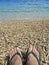 Feet in slippers on pebble beach