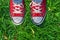 Feet in sneakers in green grass