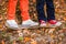 Feet in sneakers on a skateboard two children autumn