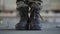 Feet of the soldier in old boots making a step forward on the dusty dirty concrete floor in an abandoned building