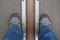 Feet stand on opposite sides of the Prime Meridian.