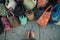 feet surrounded by assorted fabric totes on a sidewalk