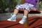 Feet of unrecognizable baby swinging on playground