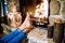 Feet of unrecognizable woman in front of the fireplace.