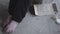 Feet of unrecognized barefoot poor girl sitting in a dusty empty in the abandoned building. A sign that says help and