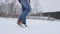 Feet walking in deep snow shot in slow motion. foot steps of hiker is showen among beautiful landscape. a young man