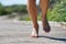 Feet of white man driving forward while running barefoot with unfocused background.