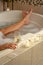 Feet of a Woman Relaxing in the Bathroom Spa Tub with a Glass of Sparkling Champagne and Candles