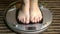 Feet of a woman standing on scales at home