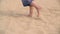Feet of woman walking in sandy desert at summertime