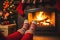 Feet in wool socks with Christmas pattern on the background of burning fireplace. A cozy winter evening. New Year.