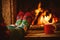 Feet in woollen socks by the Christmas fireplace. Woman relaxes