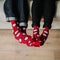 Feet in woollen socks. Pair relaxing with a cup of hot drink and warming up their feet in woollen socks.