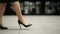Feet Of Young Business Woman In High-Heeled Footwear Going In City. Businesswoman Legs In High-Heeled Shoes Walking Near