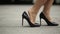 Feet Of Young Business Woman In High-Heeled Footwear Going In City. Businesswoman Legs In High-Heeled Shoes Walking Near