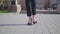 Feet of young business woman in high-heeled footwear going in the city. Female legs in high heels shoes walking in the