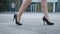 Feet of young business woman in high-heeled footwear going in the city. Female legs in high heels shoes walking in the