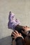 Feet of a young inline skater girl sitting on top of a ramp in a concrete skatepark. Aggressive in-line roller blader female