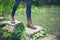 Feet of young person on stepping stones in a pond.