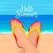Feet of a young woman on the background of the ocean with hand-written Hello Summer