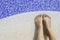 Feet of a young woman on the edge of the pool