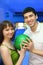 Fellow and girl turned to each other and hold ball