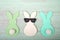 Felt bunnies in earth tone colors in a row on green table