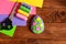 Felt Easter egg decor, scissors, thread group, needle, colored felt sheets on wooden background with copy space