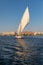 A felucca, a traditional wooden sailing boat, carrying tourists on the Nile river at Aswan