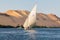 A felucca, a traditional wooden sailing boat, carrying tourists on the Nile river at Aswan