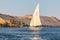 A felucca, a traditional wooden sailing boat, carrying tourists on the Nile river at Aswan